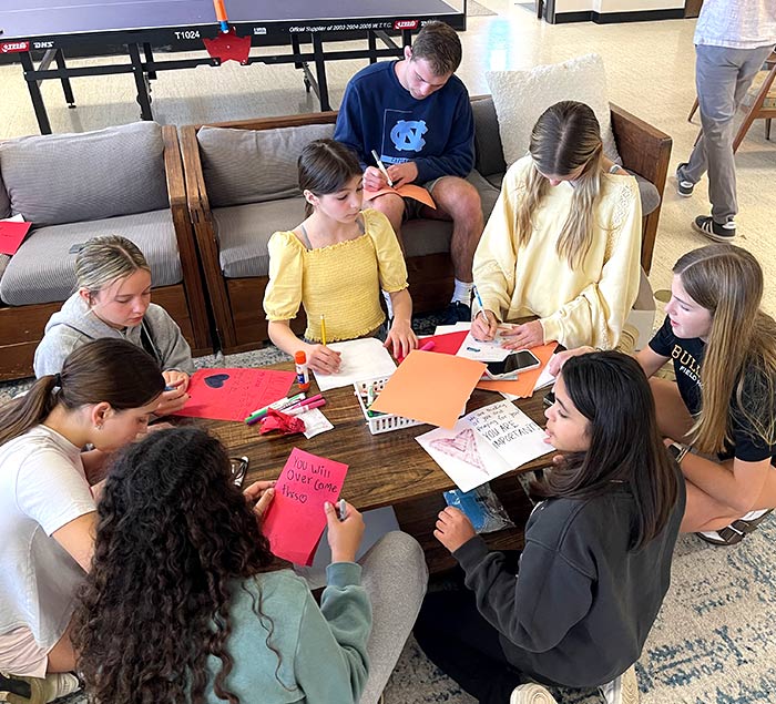 Group volunteers drawing on paper around a table
